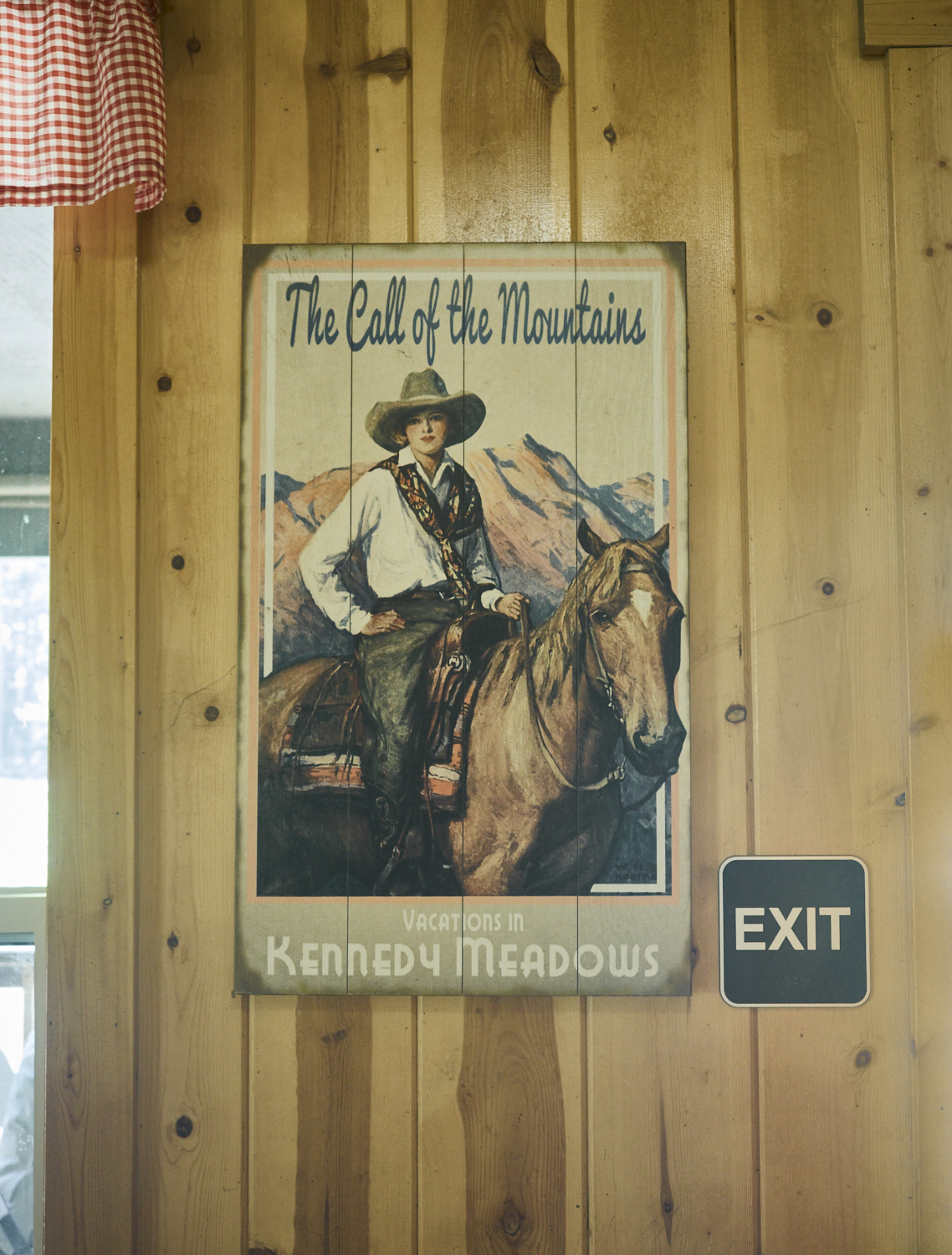 Ein Bild einer jungen Frau mit Cowboyhut auf einem Pferd hängt an der Wand eines Restaurants.