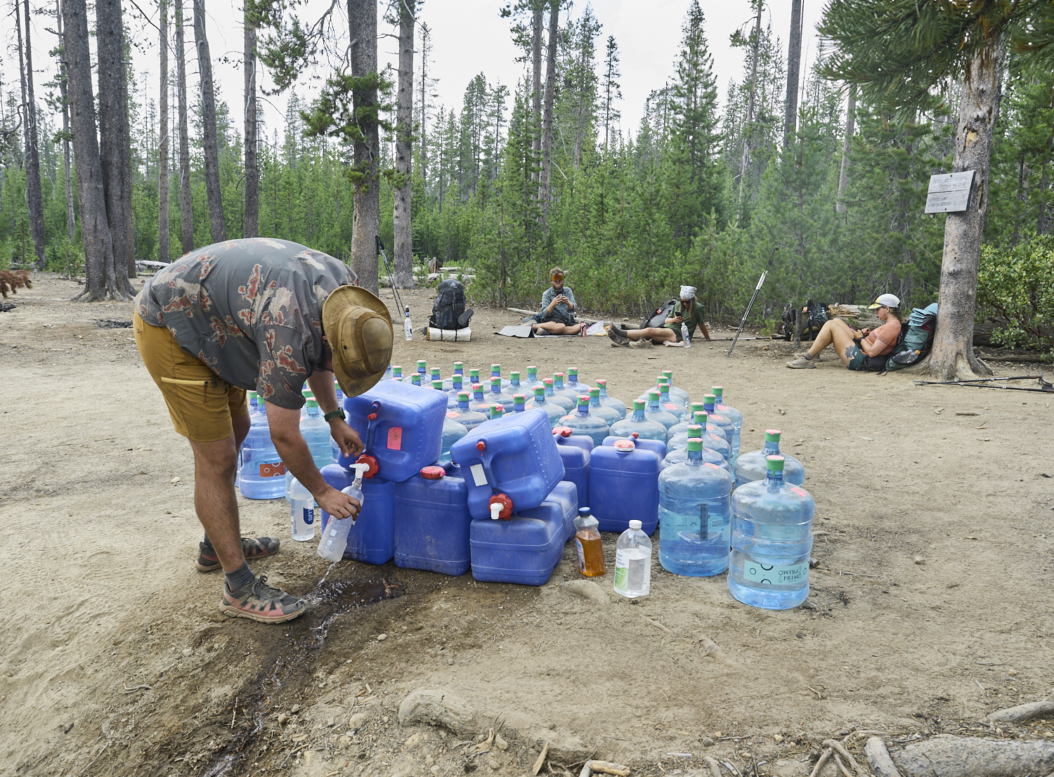 Ein Wanderer füllt seine Wasserflasche bei einem Wasservorrat auf